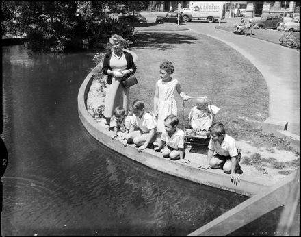"All Ages Fascinated By Fish in The Square Pond"