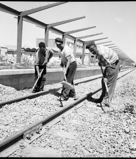 "Fifteen Miles To Go" [Men working on railway tracks]