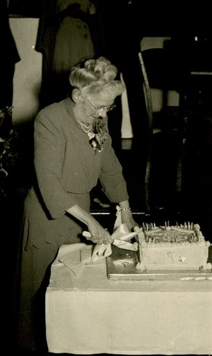 Miss Haycock cutting the cake at her celebration to mark 50 years service for C M Ross Co. Ltd