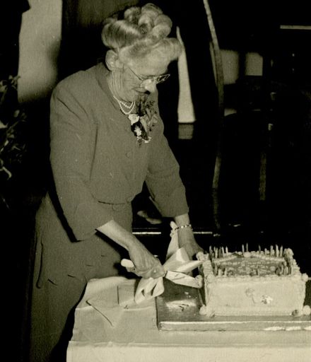 Miss Haycock cutting the cake at her celebration to mark 50 years service for C M Ross Co. Ltd