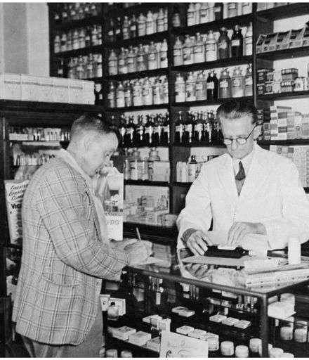 Evans Family Collection: Mr Evans in a Palmerston North pharmacy