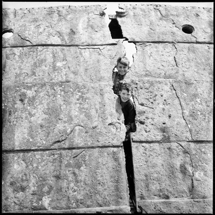 "Two Boys Looking Through Gap"