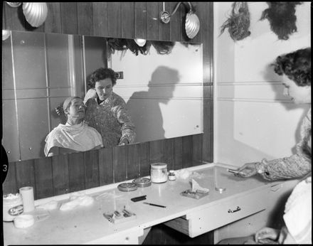 "Unknown person one having makeup applied by another."