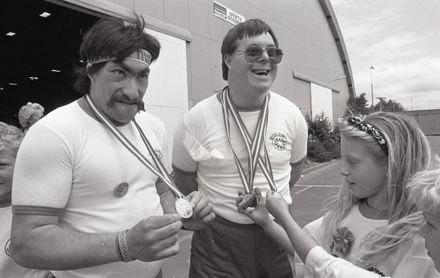 [Manawatū powerlifters John Bos and Joe Bain show their medals to autograph hunters at the 1990 Special Olympics]