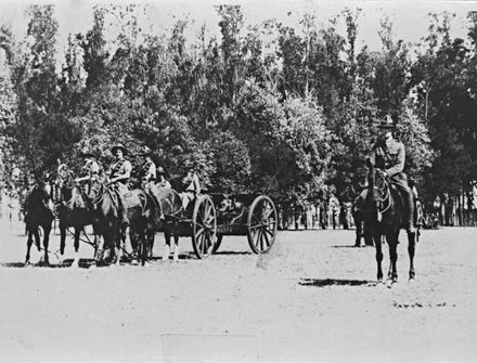 Troops on horseback, pulling a field gun.