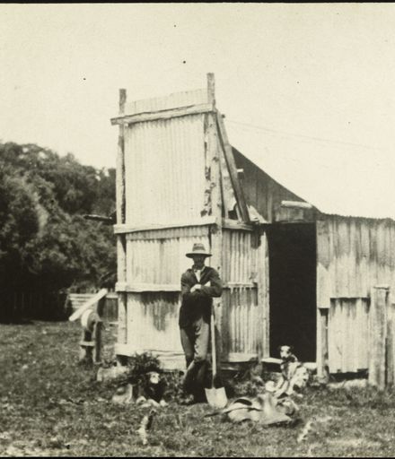 John Roots and dogs outside his whare