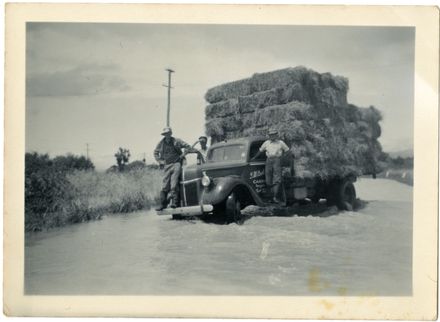 Men rescuing hay bales, Rangiotu