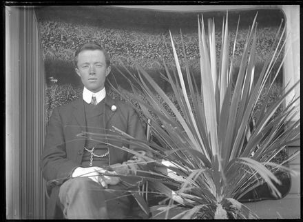Young Man Sitting by Plant