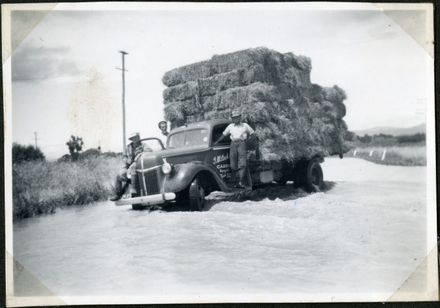 Men rescuing hay bales, Rangiotu