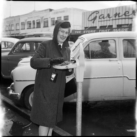 "A Finger in the Works" Meter Maid Checking Parking Meter.