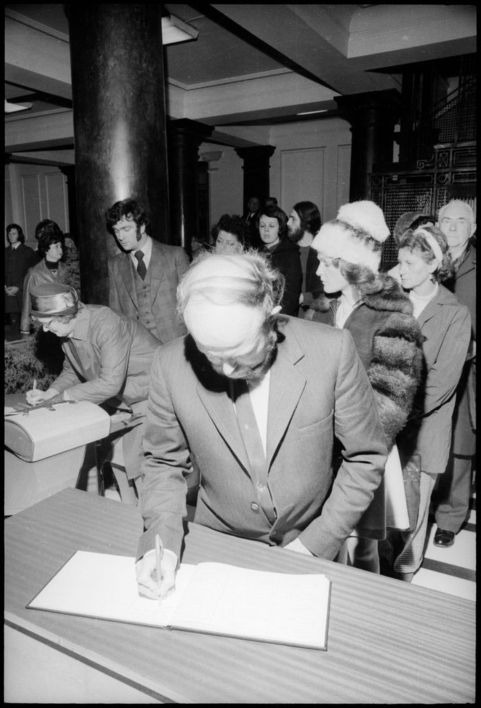 Man Signs One of Five Books of Remembrance