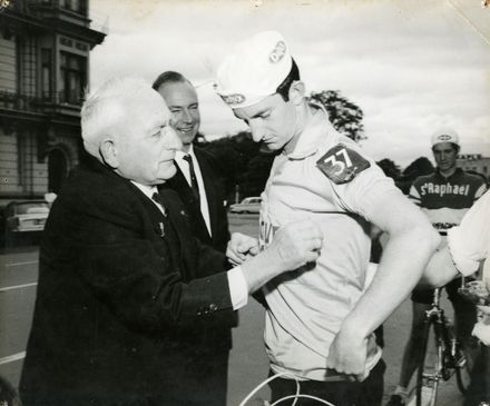 Mayor Gilbert Rennie Presents Tour Leader Sash to Cyclist Des Thompson