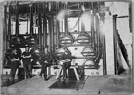 Workers seated beside gas retorts at the Palmerston North Gasworks