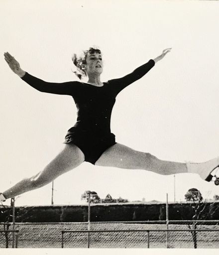 Deborah Rumsey executing split jump at Memorial Park roller skating rink, 1966