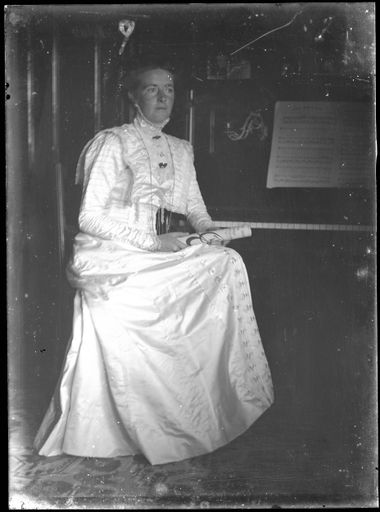 Young Woman Seated By Piano