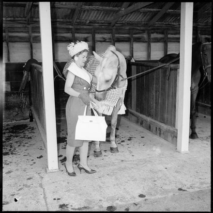 [Smartly dressed woman discouraging a horse from eating her handbag] - Resource cover image