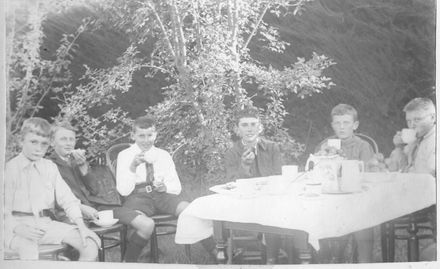 Six boys seated near table having morning or afternoon tea in garden - Resource cover image