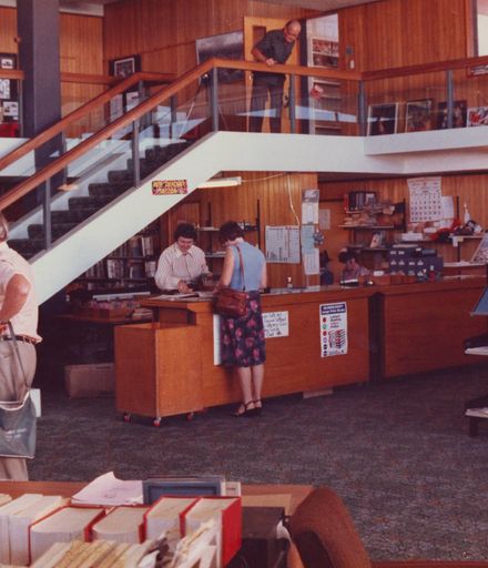 Interior of Levin Library showing issues desk beside main stairs to mezzanine, 1981