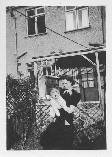 Lady in black dress holding dog. - Resource cover image