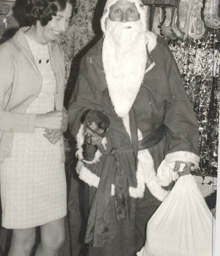 Woman (unidentified) with man (unnamed) as Santa Claus