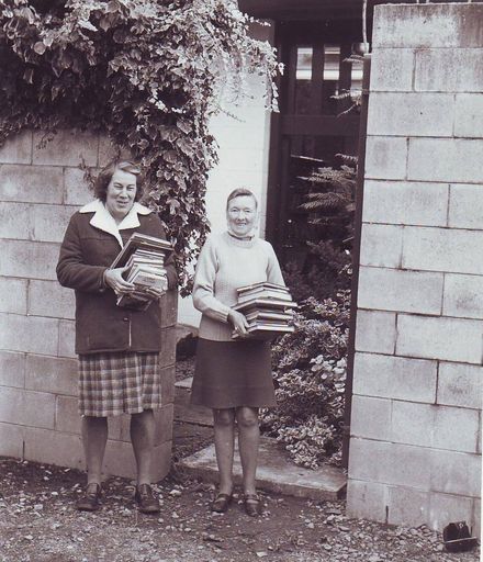 Pam Lyon and Elaine Morse carrying new stock into library, mid 1970's