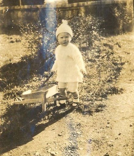 Young child with small wooden wheelbarrow
