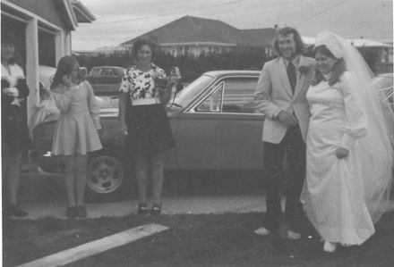 Unidentified bride & groom with 3 female onlookers, 1970's
