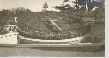 Large mechanical clock set in flower garden