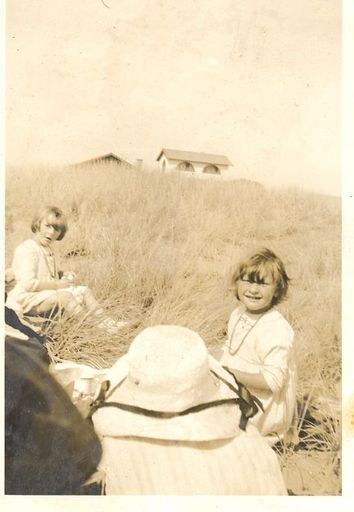 Young girls in sand hills at the beach. - Resource cover image