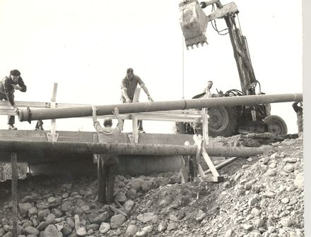 Replacing pipes alongside bridge