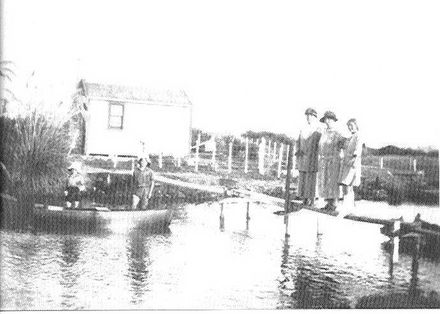 Cottage & people beside Hokio Stream