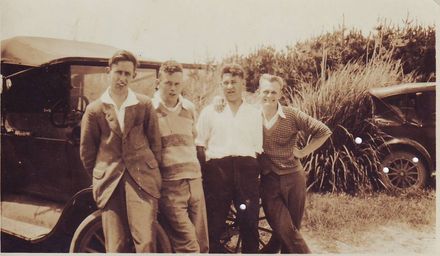 Four young men in front of car