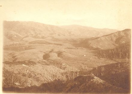 View of valley with cleared bush & building