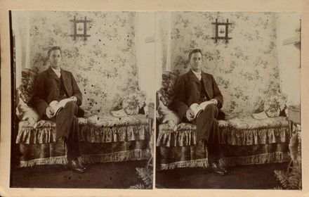 Mr Jas. (James) Hallam seated on divan with book in lap, Shannon, 1906