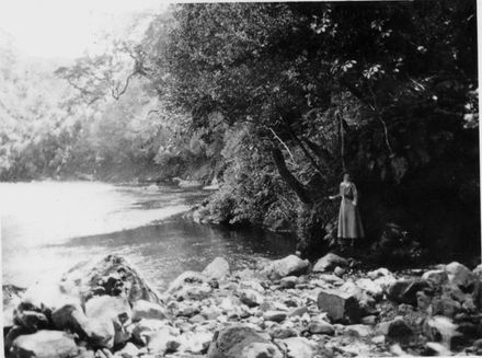 Woman (unidentified) standing beside river, early 1920's