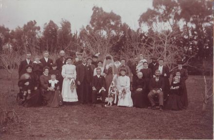 Unidentified wedding group with dog in orchard