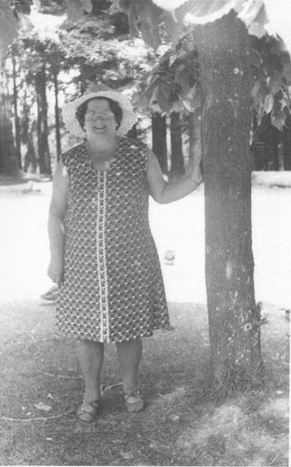 Betty Sharps standing beside tree