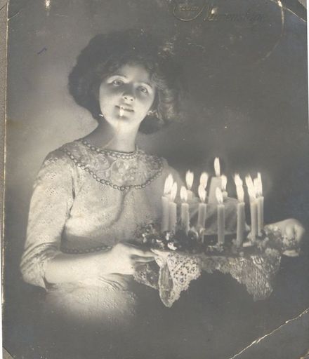 Young woman with birthday cake. c1914-18.