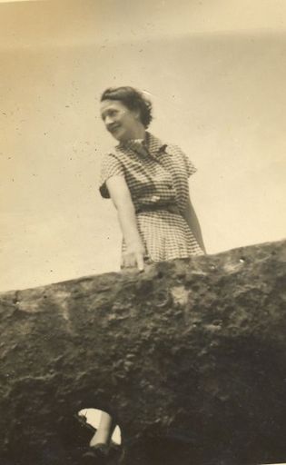 Woman standing by concrete wall