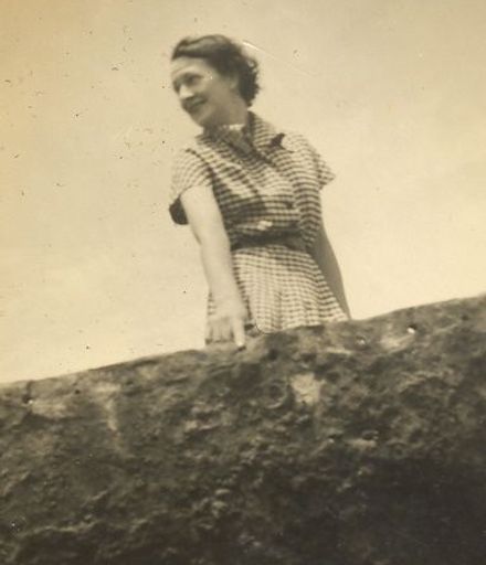 Woman standing by concrete wall
