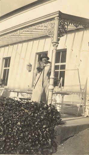 Woman standing under a veranda.