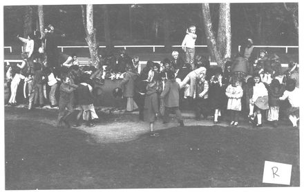 Children grouped together in unidentified playground ?