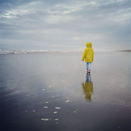 Girl in a raincoat at Waitārere Beach - #CaptureYourHorowhenua - Resource cover image