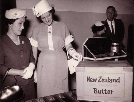 Factory tour - two women (left) view butter box, man in background (right)