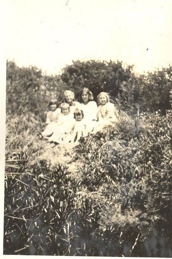 6 girls sitting amongst vegetation