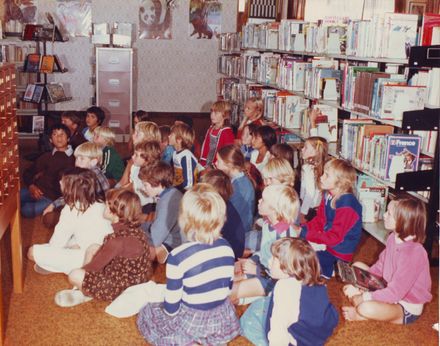 Interior of Otaki Library showing 28 children sitting on floor during class visit, 1981