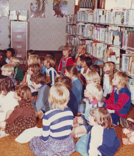 Interior of Otaki Library showing 28 children sitting on floor during class visit, 1981