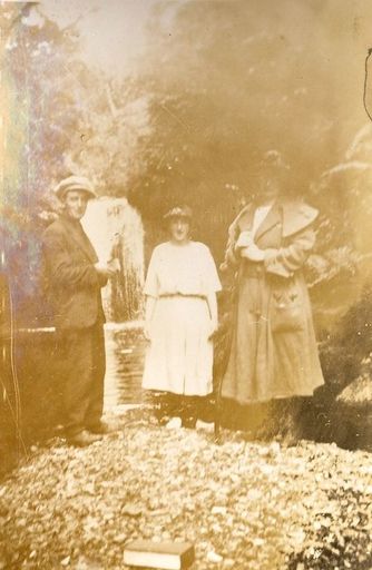 Threesome in front of a waterfall.