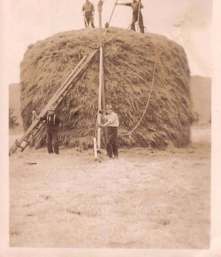 Men building haystack