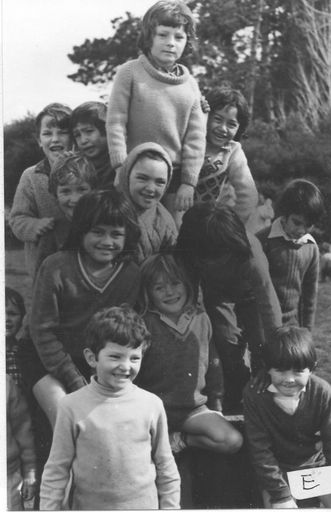 Another view of children grouped on old tractor in playground